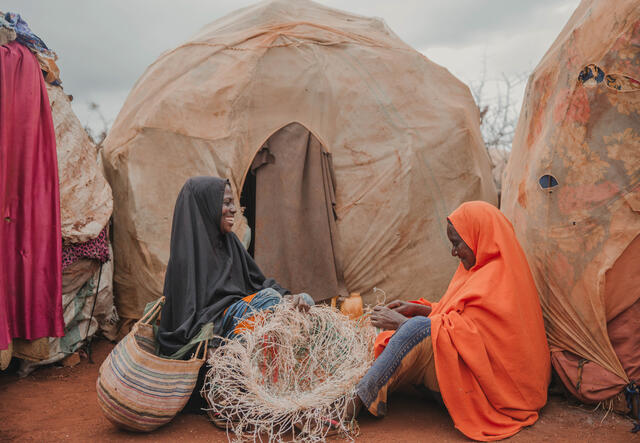 Nunay and Bigisow sat in front of their tents, making baskets.